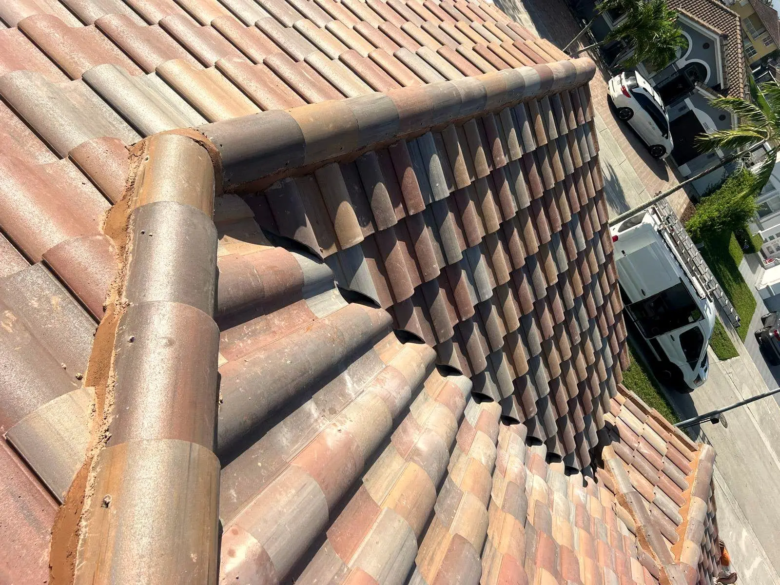 Clay barrel tile courses meeting at a hip set in mortar